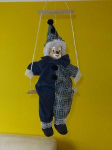 porcelanowa lalka na huśtawce -pajac klaun